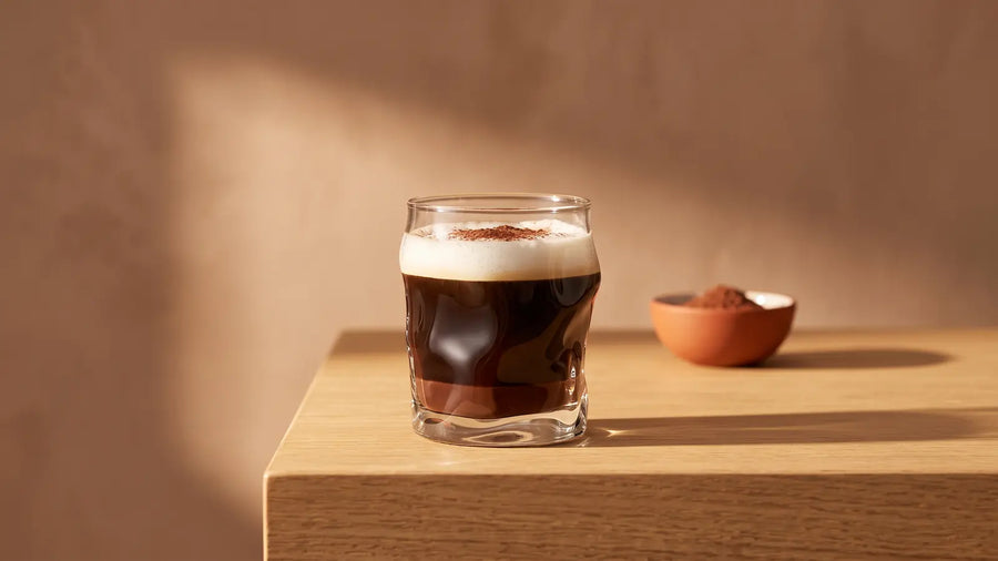 Marocchino im kleinen Glas mit Kakao, Espresso und Milchschaumhaube