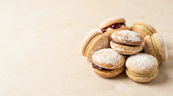 Amaretti Mauro gepuderte Mandel-Sandwichkekse mit Füllung auf hellem Marmor