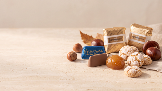 Italienische Herbst-Spezialitäten: Gianduiotto, Marrons Glacés und Amaretti auf warmem Stein
