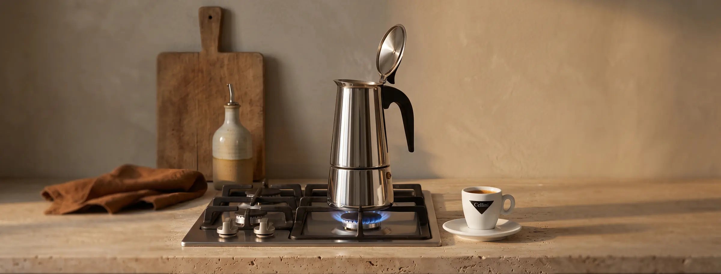 Espressokocher auf der Gasflamme, daneben eine Cellini-Espressotasse